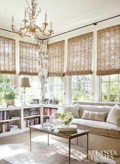 a living room filled with furniture and windows covered in shades of bamboo covering the window