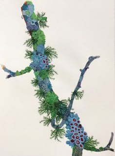 an image of a lizard made out of flowers and pine cones on a tree branch