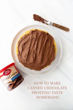 a chocolate frosted cake sitting on top of a white plate next to a can of ice cream