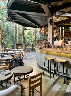 the inside of a restaurant with wooden tables and stools in front of large windows