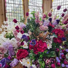 a vase filled with lots of different colored flowers