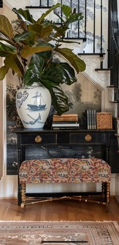 a plant in a vase sitting on top of a table next to a stair case