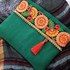 a green pillow with an orange tassel on it