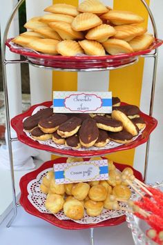 three tiered trays filled with cookies and pastries on top of a table