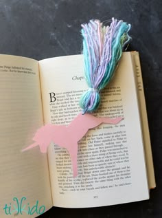 an open book with yarn on it and a unicorn cut out of the pages to look like a horse