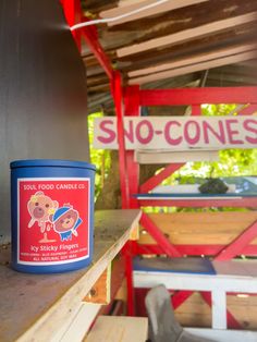 a blue candle sitting on top of a wooden table next to a red and white sign