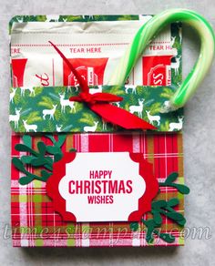 a christmas present wrapped in red and green paper with a candy cane attached to it