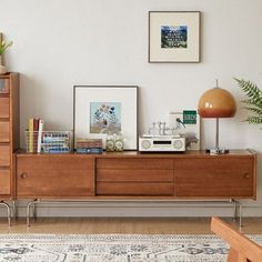 a living room with a dresser, bookshelf and various pictures on the wall