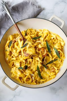 a bowl filled with pasta and topped with sage