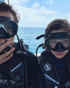 two people wearing scuba gear on a boat