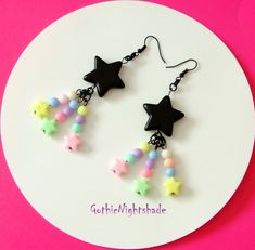 MADE TO ORDER!     Here we have some awesome Cute Earrings.  The Shooting Stars consist of a Black Star and three shooting stars per earring.  Shooting stars are made up of round and star pastel beads.  They hang on black Hypoallergenic ear hooks and the drop length is approximately 8cm.  These Kawaii Earrings would make a Great Gift for someone special or for yourself! Handmade, and will be packaged in a pretty organza gift bag. Visit my shop to see the complete collection of Pastel Goth Jewell Pastel Goth Choker, Pastel Goth Earrings, Studio Ghibli Earrings, Goth Jewellery, Wicca Necklace, Goth Choker, Pastel Kawaii, Goth Necklace, Goth Earrings