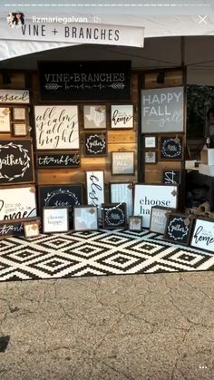 wine and branches booth at an outdoor event with lots of signs on the front wall