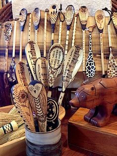 wooden spoons are hanging on the wall next to an elephant figurine and other items