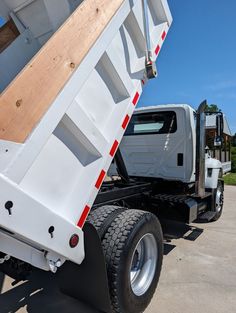 a white dump truck parked in a parking lot