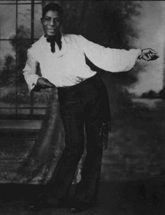 a black and white photo of a man in a tuxedo with his arms outstretched