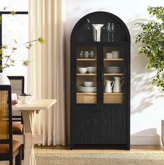 a black cabinet with glass doors in a dining room