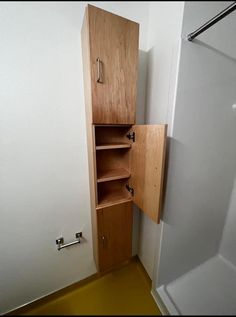 an empty bathroom with a wooden cabinet in the corner