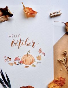 the hello october card is surrounded by autumn leaves and acorns on a white surface