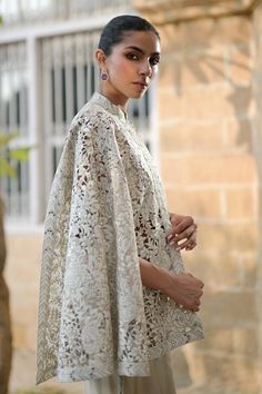 a woman wearing a white shawl and dress