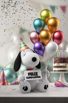 a stuffed dog holding balloons in front of a birthday cake