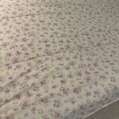 the bed is made up with pink flowers on it