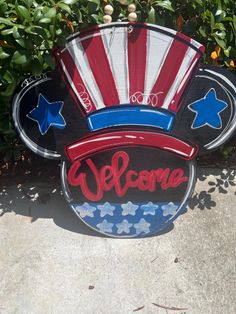 the welcome sign is painted red, white and blue with an american flag fan on it