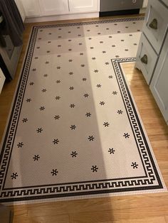 a kitchen area with a rug on the floor and cabinets in the backround