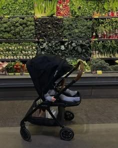 a baby stroller in front of a display of vegetables