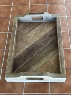 a wooden tray sitting on top of a tiled floor