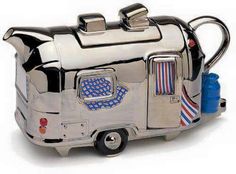 a silver teapot shaped like a camper with a flag on the side and an american flag tie hanging from it