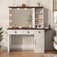 a white vanity with lights on it in a room next to a bed and potted plant