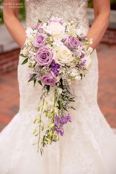 a bridal holding a bouquet of purple and white flowers