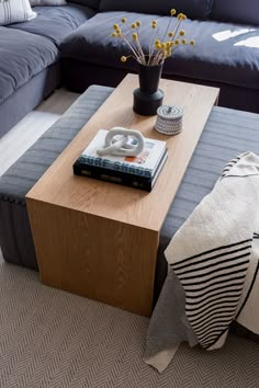 a living room with a couch, coffee table and pillows on the floor in front of it