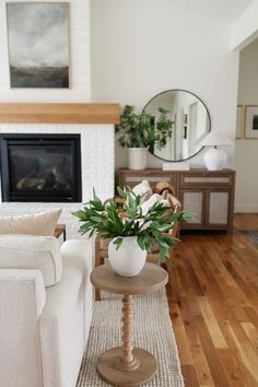 a living room filled with furniture and a fire place in front of a white fireplace