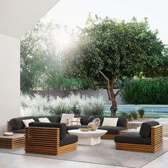 a living room filled with furniture next to a tree and grass covered field in the background