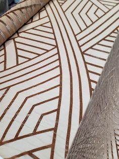 a close up view of a bed with brown and white designs on it