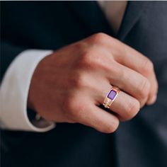 a man in a suit and tie wearing a ring with an amethorate stone