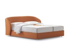 an orange bed with white sheets and pillows