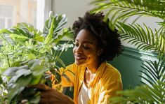 a woman is smiling while looking at plants