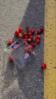 some strawberries laying on the ground next to a yellow line