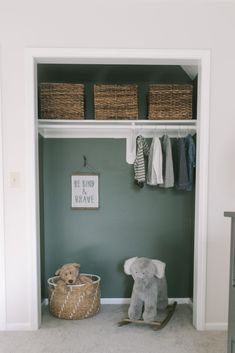 a baby's room with green walls and white closet doors, stuffed animal on rocking horse