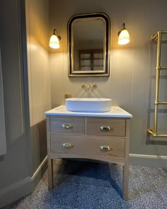 a white sink sitting under a bathroom mirror