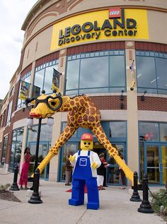 a giant lego giraffe standing in front of a building