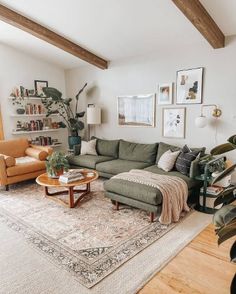 a living room filled with furniture and lots of greenery on the wall next to a large window