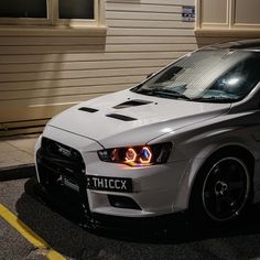 a white car parked in front of a building