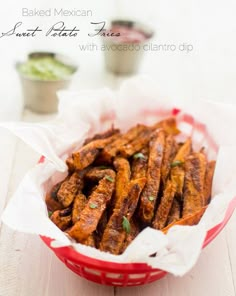 baked mexican sweet potato fries with avocado cilantro dip in a red basket