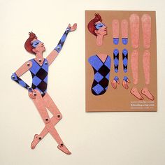 a paper cut out of a woman in blue and black is next to a piece of cardboard