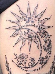 a woman's back with a sun and moon tattoo on it, surrounded by flowers