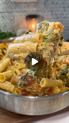 a pan filled with pasta and broccoli being lifted from the pot by a ladle