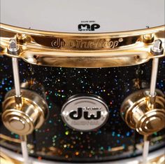 a close up view of the front end of a drum with gold and black sparkles